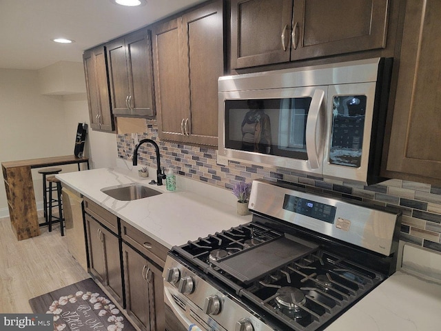 kitchen with dark brown cabinets, appliances with stainless steel finishes, and sink