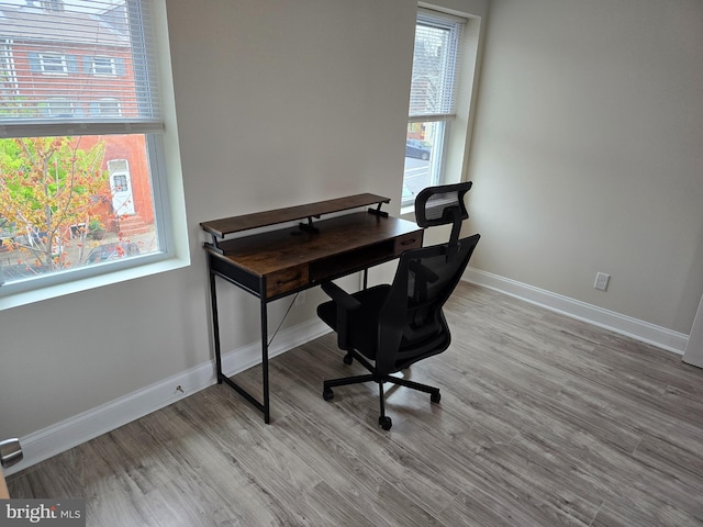 home office with a wealth of natural light and light wood-type flooring