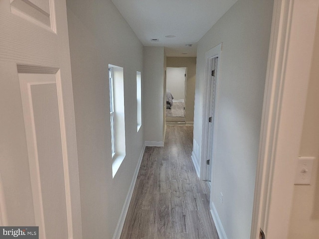 hallway with light hardwood / wood-style floors