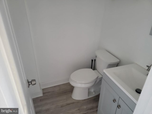 bathroom featuring vanity, toilet, and hardwood / wood-style flooring