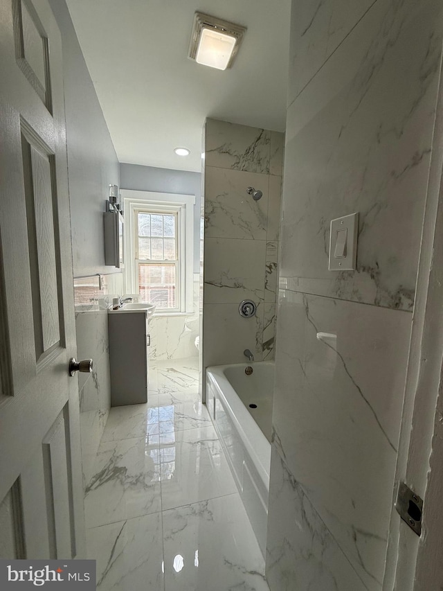 bathroom featuring vanity and tiled shower / bath