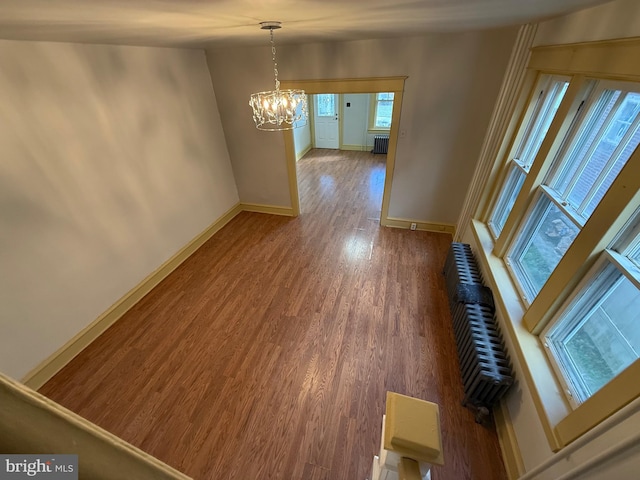 interior space with an inviting chandelier, radiator, and dark hardwood / wood-style flooring