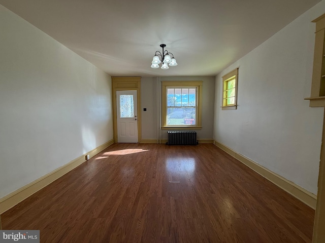 interior space with radiator heating unit, a chandelier, and dark hardwood / wood-style flooring