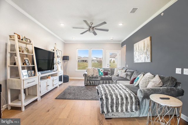 living room with light hardwood / wood-style flooring, ornamental molding, and ceiling fan