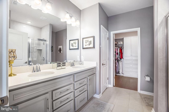 bathroom featuring a shower with door, tile patterned floors, and vanity