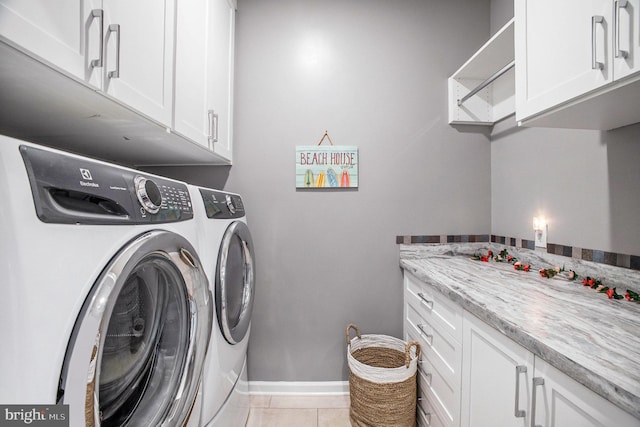 washroom with washer and clothes dryer, light tile patterned floors, and cabinets