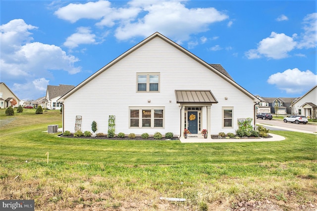 view of front of home with cooling unit and a front lawn