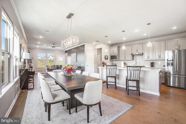 dining area with ceiling fan, hardwood / wood-style flooring, and crown molding