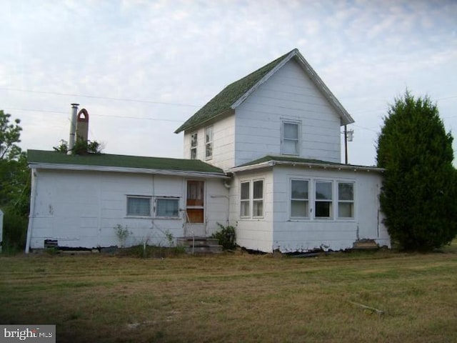 back of property featuring a lawn