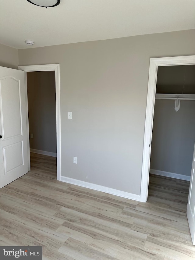 unfurnished bedroom with light hardwood / wood-style floors and a closet