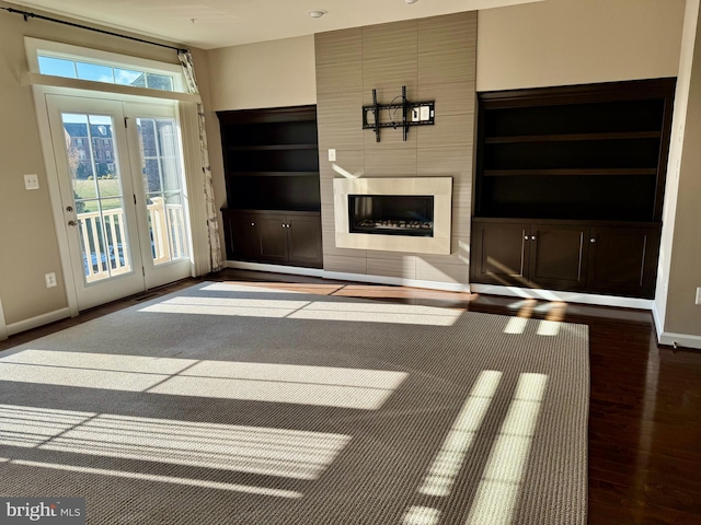 unfurnished living room with built in features, french doors, and hardwood / wood-style flooring