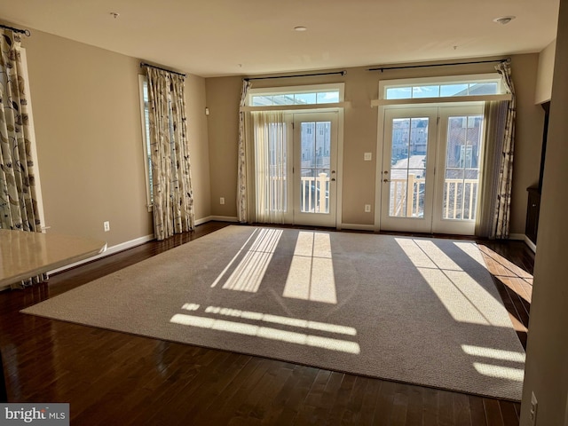 empty room with dark hardwood / wood-style flooring and french doors