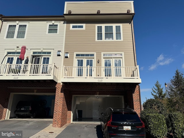 back of house with a balcony and a garage