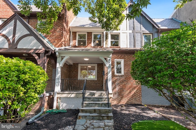 english style home with covered porch