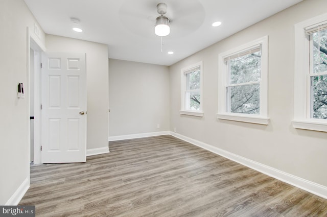 spare room featuring ceiling fan, plenty of natural light, and light wood-type flooring