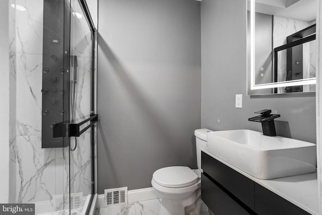 bathroom featuring vanity, toilet, and a shower with shower door