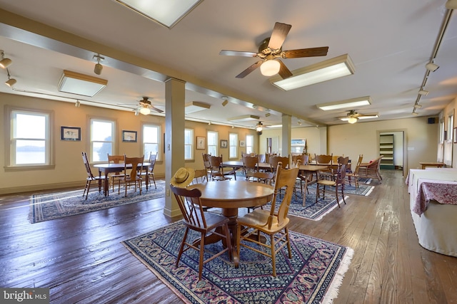 dining area with track lighting, dark hardwood / wood-style floors, and ceiling fan