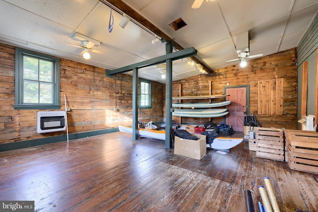 interior space featuring wooden walls, wood-type flooring, and heating unit