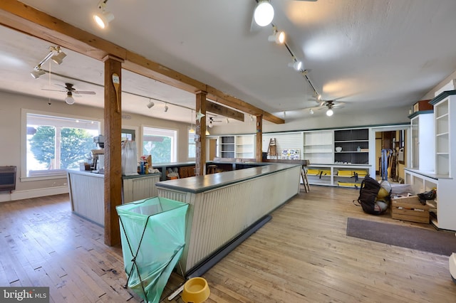 kitchen featuring light hardwood / wood-style floors, beam ceiling, track lighting, and a kitchen island