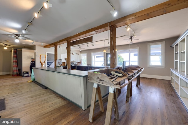 kitchen featuring rail lighting, kitchen peninsula, and hardwood / wood-style floors