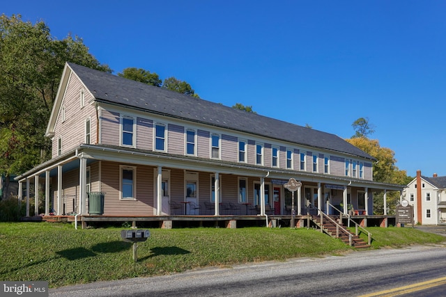 view of front of house featuring covered porch and a front lawn