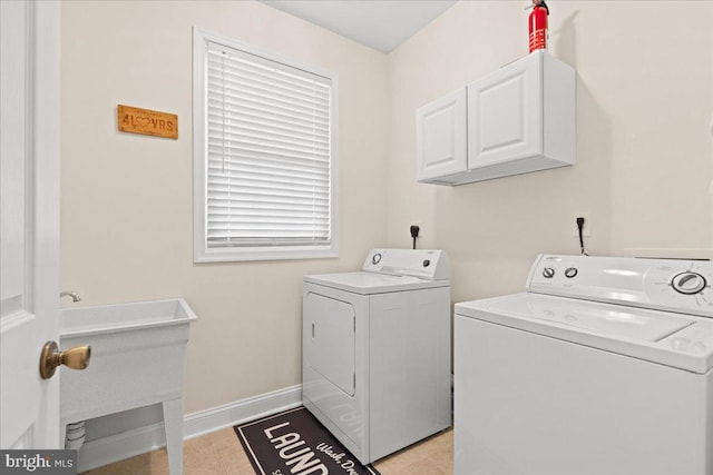 laundry area featuring cabinets, light tile patterned flooring, and washing machine and clothes dryer