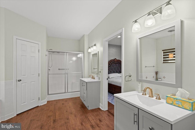 bathroom with wood-type flooring, vanity, and an enclosed shower