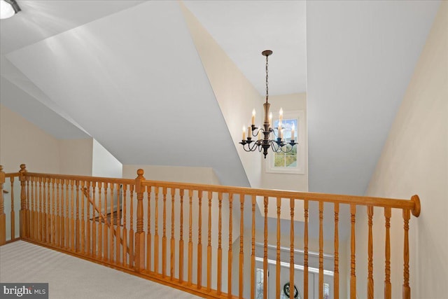 interior space with a chandelier, carpet flooring, and lofted ceiling