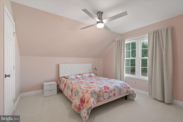 bedroom with ceiling fan, light carpet, and vaulted ceiling