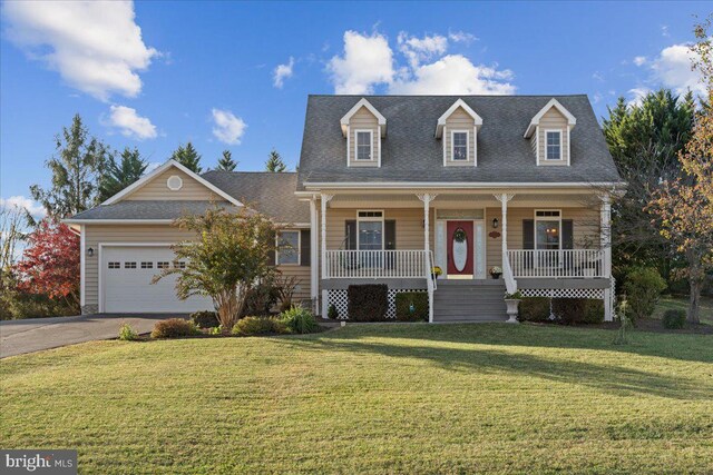 new england style home featuring a garage, covered porch, and a front yard