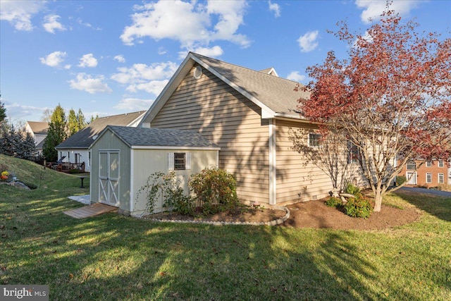 view of side of home featuring a lawn and a storage unit