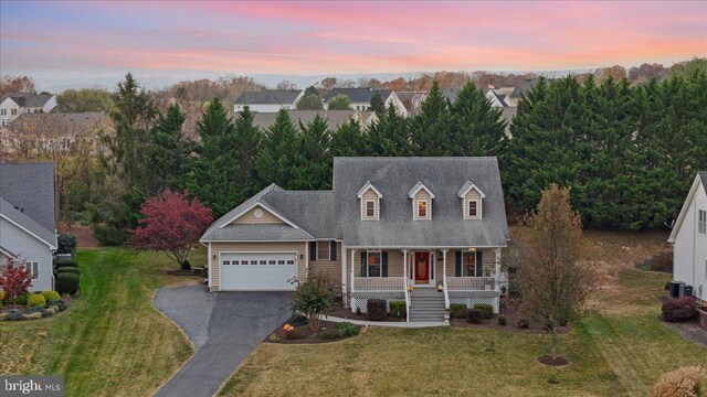 cape cod home with a lawn, central air condition unit, a porch, and a garage