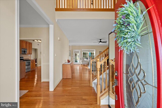 entryway with ceiling fan, crown molding, and light hardwood / wood-style flooring