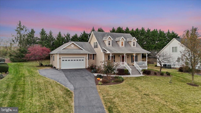 cape cod home with a lawn, a porch, and a garage