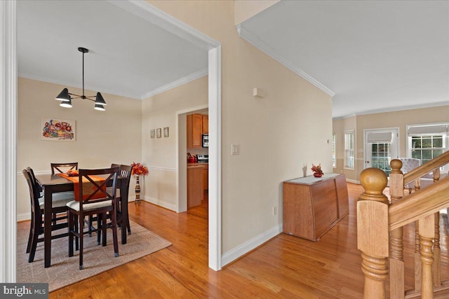 dining area featuring ornamental molding and light wood-type flooring