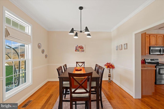 dining area featuring crown molding, light hardwood / wood-style floors, and a notable chandelier