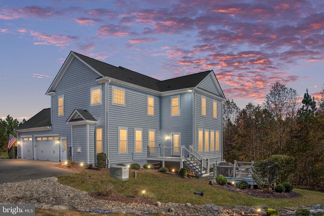 view of front of home with a garage and cooling unit