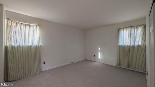 carpeted spare room featuring a wealth of natural light