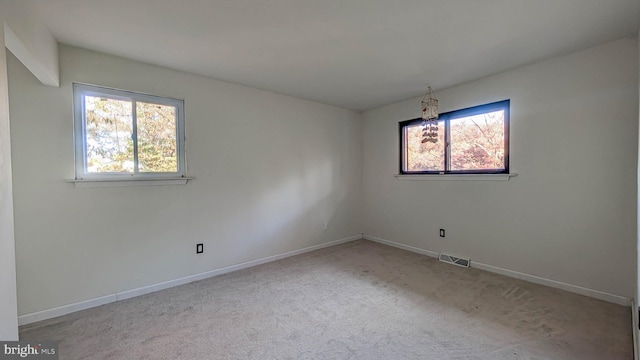 carpeted spare room featuring a healthy amount of sunlight