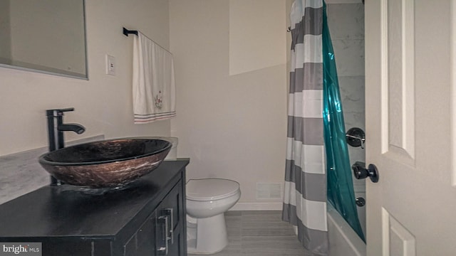 full bathroom with vanity, shower / bath combo, and toilet