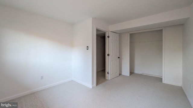 unfurnished bedroom featuring a closet and light carpet