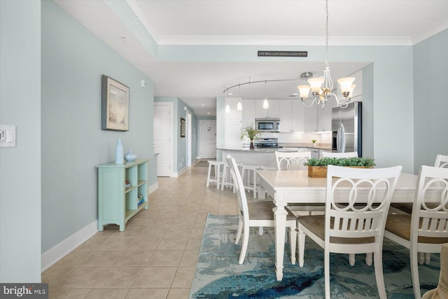 dining space featuring a notable chandelier, crown molding, and light tile patterned floors