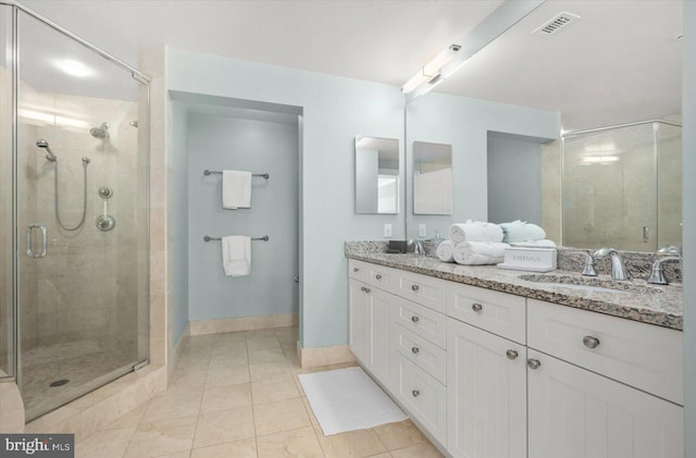 bathroom featuring vanity, a shower with shower door, and tile patterned flooring