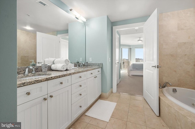 bathroom with vanity, a relaxing tiled tub, tile patterned floors, and ceiling fan