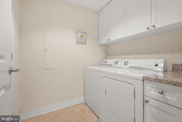 laundry room with washer and dryer, light tile patterned floors, and cabinets