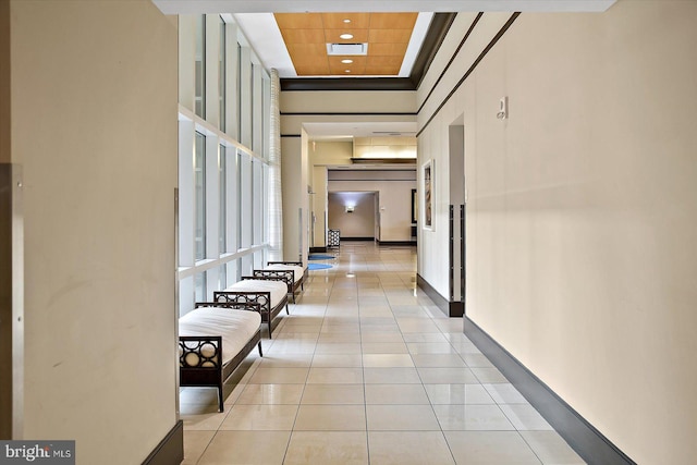 hall with light tile patterned flooring and a high ceiling