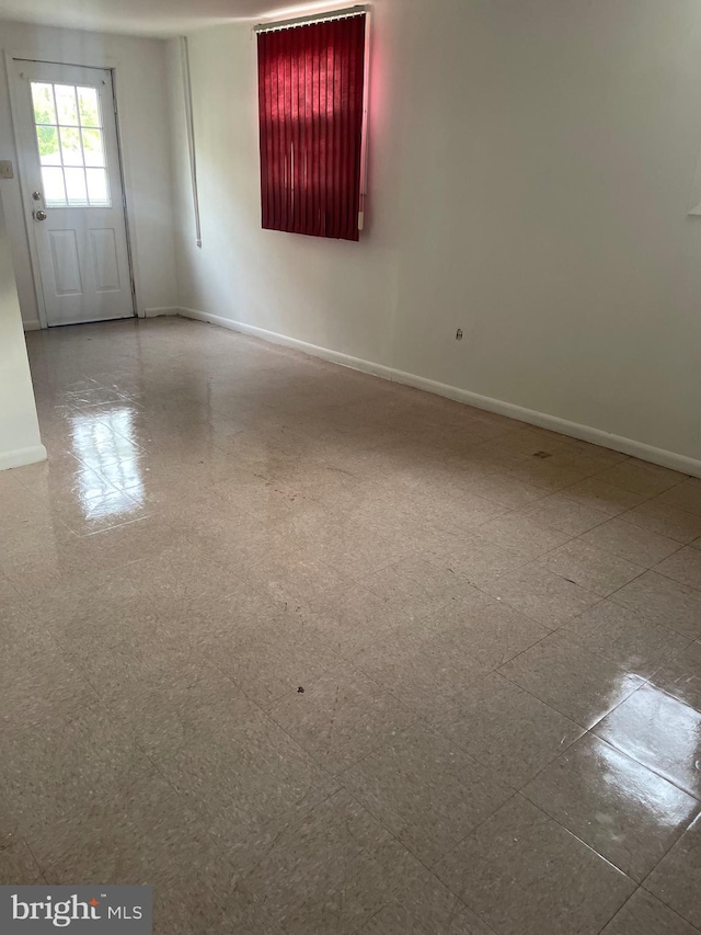 unfurnished room with baseboards
