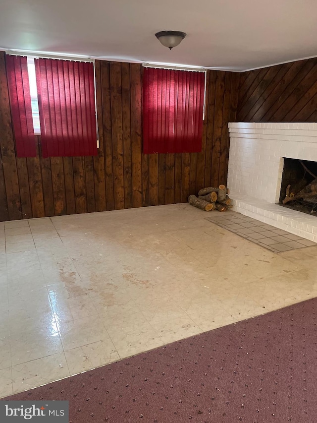 interior space with tile patterned floors, wooden walls, and a brick fireplace