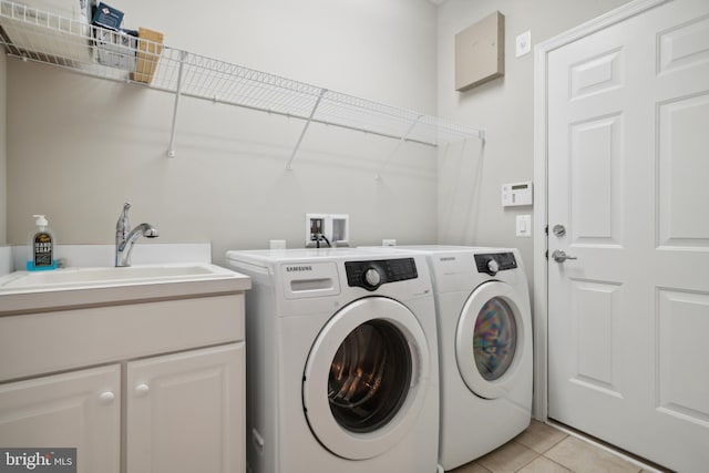 laundry room featuring cabinets, sink, washing machine and dryer, and light tile patterned floors