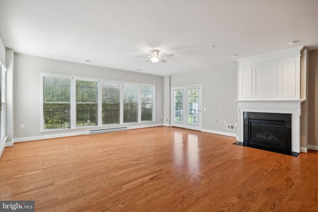 unfurnished living room featuring light hardwood / wood-style floors, baseboard heating, and ceiling fan